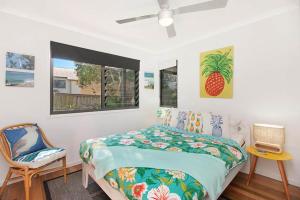 - une chambre avec un lit et deux chaises dans l'établissement Casuarina Cabana Beach House, à Casuarina