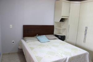 um quarto com uma cama com uma almofada azul em Chácara da Bia em Várzea Grande