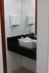 Un baño con un lavabo blanco y un espejo. en Chácara da Bia, en Várzea Paulista