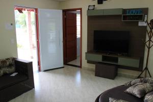a living room with a flat screen tv and a couch at Chácara da Bia in Várzea Paulista