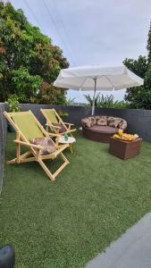 Un césped con dos sillas y una sombrilla y una cama para perros. en Chácara da Bia, en Várzea Paulista