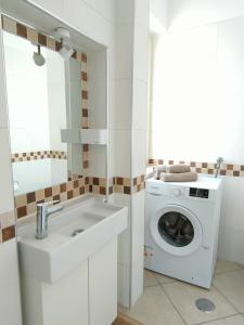 uma casa de banho com uma máquina de lavar roupa e um lavatório em Serao House, 2 piano in centro em Mondragone