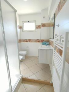 uma casa de banho branca com um WC e um lavatório em Serao House, 2 piano in centro em Mondragone