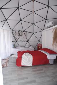 a bedroom with a red and white bed and a ceiling at Eco Cabañas Montana - Glamping 2 