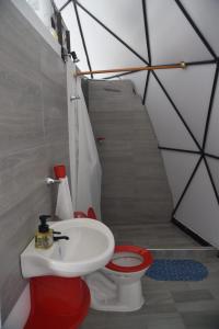 a bathroom with a red toilet and a sink at Eco Cabañas Montana - Glamping 2 