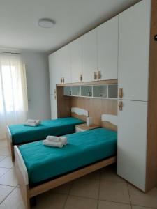 um quarto com 2 camas e um frigorífico em Serao House, 2 piano in centro em Mondragone