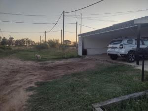 ein Auto, das vor einer Garage mit einem Hund parkt in der Unterkunft Alojamiento en Chajarí in Chajarí