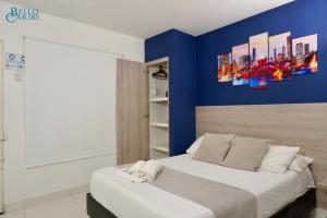 um quarto com uma parede azul e uma cama em Hotel Bello Caribe em Santa Marta