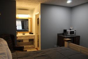 a bedroom with a bed and a bathroom with a sink at Heidi Motel - Helen in Helen +37 photos