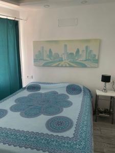 een slaapkamer met een bed met een quilt bij wonderful white appartament in las Tortugas in Arona