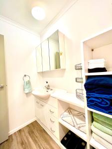 uma casa de banho branca com um lavatório e um espelho em Lake life with a hot tub em Mangakino
