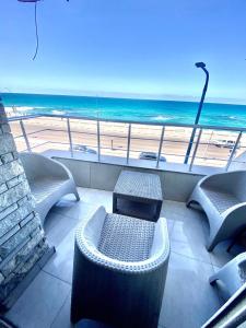 uma varanda com cadeiras e vista para a praia em Alexandria Luxury Apartments Sporting Direct Sea View em Alexandria