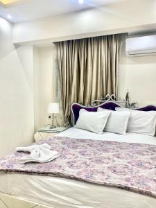 a bedroom with a large bed and a window at Alexandria Luxury Apartments Sporting Direct Sea View in Alexandria