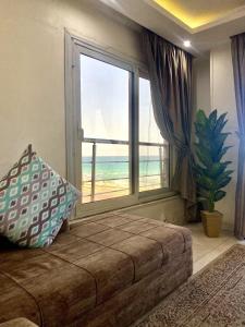 a bedroom with a large window with a view of the beach at Alexandria Luxury Apartments Sporting Direct Sea View in Alexandria