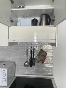 una cocina con una estantería con utensilios. en wonderful white appartament in las Tortugas, en Arona