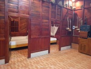 Zimmer mit holzgetäfelten Wänden und einem Schlafzimmer in der Unterkunft Cứ A Lồng Homestay in Bản Hon