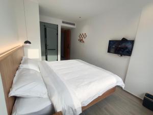 1 dormitorio con 2 camas con sábanas blancas en Huang Mountain Wangfeng Hotel, en Huangshan Scenic Area