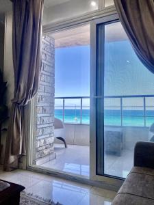 a room with a sliding glass door with a view of the ocean at Alexandria Luxury Apartments Sporting Direct Sea View in Alexandria