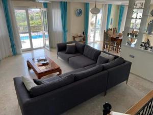 a living room with a couch and a table at Villa Ruya with swimming pool & stunning sea views in Fethiye