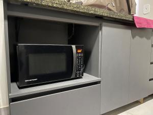 a microwave oven in a cabinet in a kitchen at CHARMOSO E BEM LOCALIZADO in Maracaju