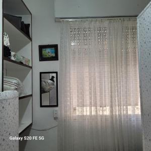 a window with white curtains in a room at Apto no Embaré pé na areia in Santos