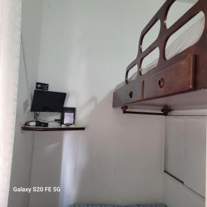 a room with a laptop on a shelf on the wall at Apto no Embaré pé na areia in Santos