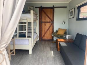 un soggiorno con letti a castello e divano di Hayshed Cabins - Merigan Farm Stay a Tarago