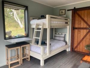 due letti a castello in una stanza con finestra di Hayshed Cabins - Merigan Farm Stay a Tarago