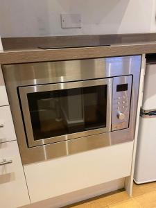 a stainless steel microwave oven in a kitchen at Studio apartment near Sutton, Croydon in Banstead