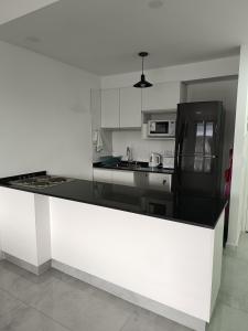 een keuken met een zwarte koelkast en witte kasten bij Torres Brickell. in Tigre