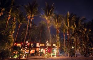 un grupo de palmeras frente a un edificio en Hotel Laguna del Cocodrilo en Tamarindo