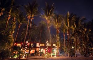 eine Gruppe von Palmen vor einem Gebäude in der Unterkunft Hotel Laguna del Cocodrilo in Tamarindo