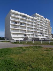 讷沙泰勒阿尔代洛Espadon的一座白色的大公寓楼,前面设有草坪