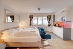 a bedroom with a bed and a blue chair at Good Value Apartments by Mountain Exposure in Zermatt