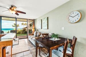 una sala da pranzo con tavolo e orologio di Polynesian Shores 112 a Kahana Altre 21 foto