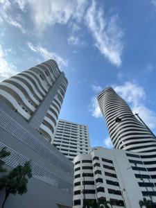 two tall white buildings against a blue sky at Departamento con Piscina en el último piso del edificio in Guayaquil
