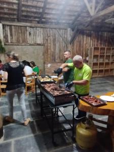 eine Gruppe von Menschen, die um einen Tisch mit Essen stehen in der Unterkunft Hotel Fazenda Rancho Grande in Linha Blinda