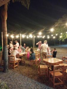 a group of people sitting at tables under a tent at Hotel Fazenda Rancho Grande in Linha Blinda