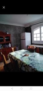 a room with a table and a kitchen with a refrigerator at Villa de campagne dans les hauteurs, vue panoramique sur mer in Ghazaouet