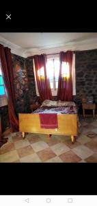 a bedroom with a bed and a window with curtains at Villa de campagne dans les hauteurs, vue panoramique sur mer in Ghazaouet