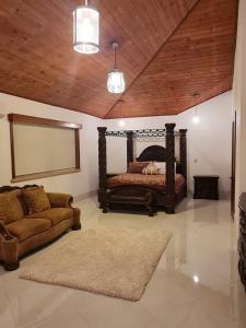 Beach view villa في Long Swamp: غرفة نوم بسرير واريكة في غرفة