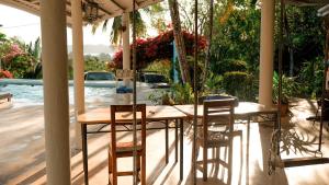 a wooden table and chairs on a patio with a pool at Hotel Sol y Mar in Santa Catalina