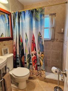 a bathroom with a shower curtain with surfboards at IRB SURF HOUSE Waterfront Oasis+ Sunshine +Fun Kayaks in Clearwater Beach