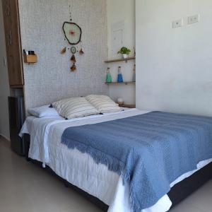 ein Schlafzimmer mit einem Bett mit einer blauen Decke in der Unterkunft Apartamento frente al mar Rodadero Santa Marta in Santa Marta