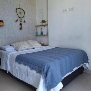 1 dormitorio con 1 cama con manta azul en Apartamento frente al mar Rodadero Santa Marta, en Santa Marta