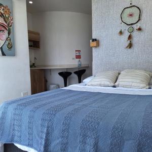 a bedroom with a bed with a blue comforter at Apartamento frente al mar Rodadero Santa Marta in Santa Marta