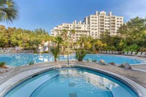 uma grande piscina com um grande edifício ao fundo em Grand Sandestin 2210 em Destin