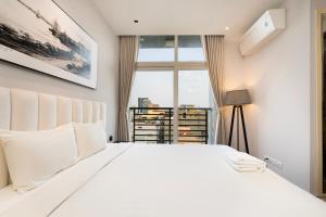 Un dormitorio con una gran cama blanca con ventana. en The Rixx Luxury Apartment, en Ho Chi Minh 37 fotos más