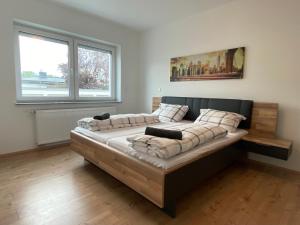 Simplex Apartments In Bruchsal في بروشسال: سرير كبير في غرفة بها نافذتين