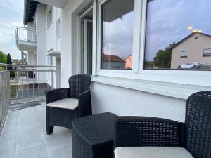 balcón con 2 sillas y ventana en Simplex Apartments In Bruchsal, en Bruchsal